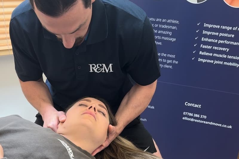 Treatment in the clinic room with the Restore & Move logo on the wall