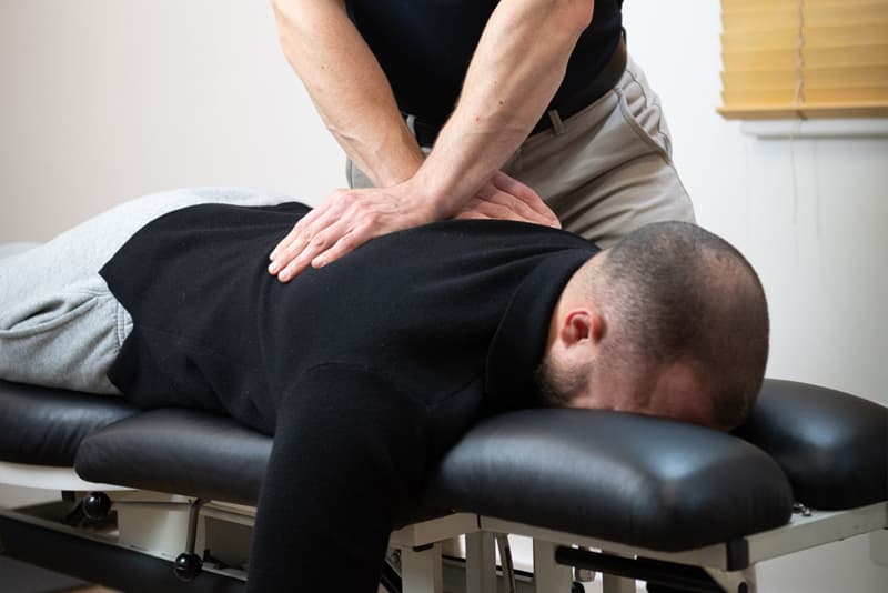 Dr Elliot Ward treating a patient lying face down